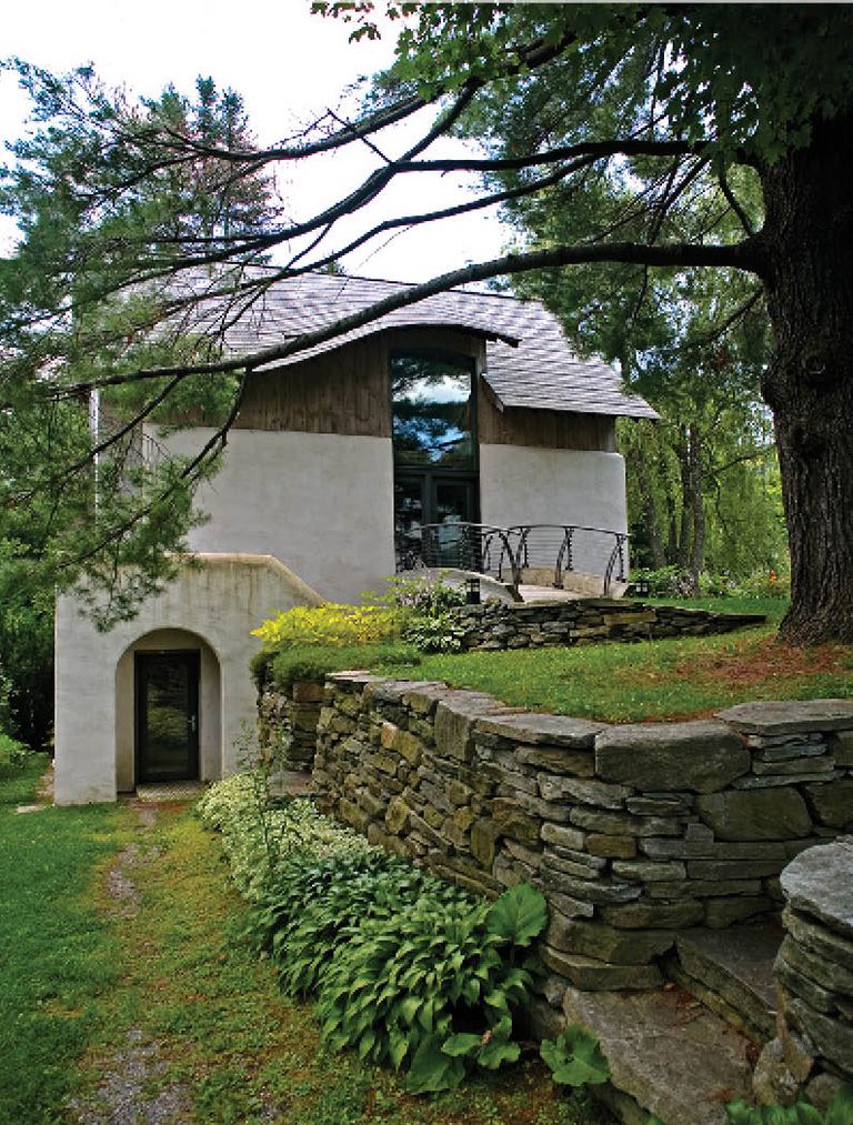 Plaster exterior with punctured windows and sweeping roof