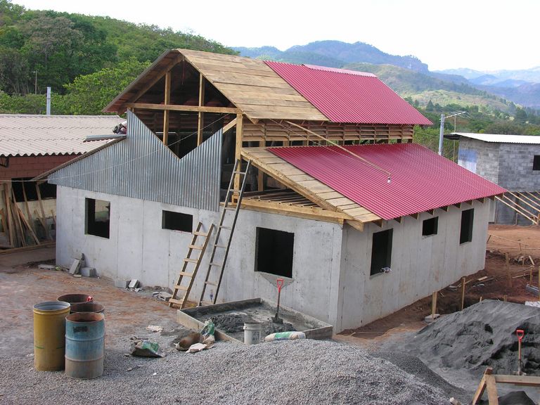 Construction photo of stucco and metal building with metal roof