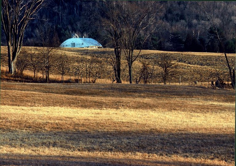 Corrugated, galvanized steel arch-shaped facade in a field