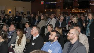 The audience watches the AIAVT presentations