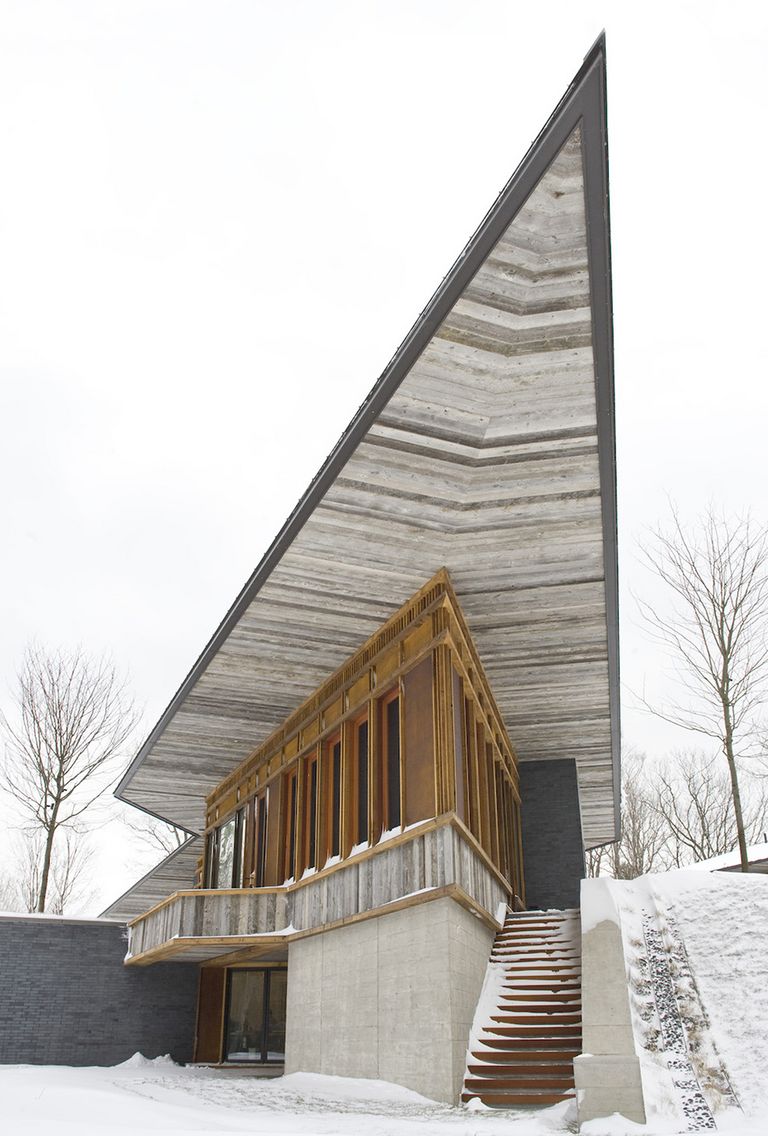 glazed wood residence with acute angled cantilevering roof