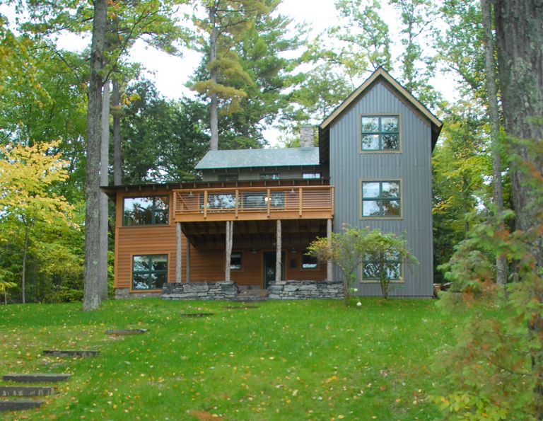 natural wood gray sided gabled building w/ high deck