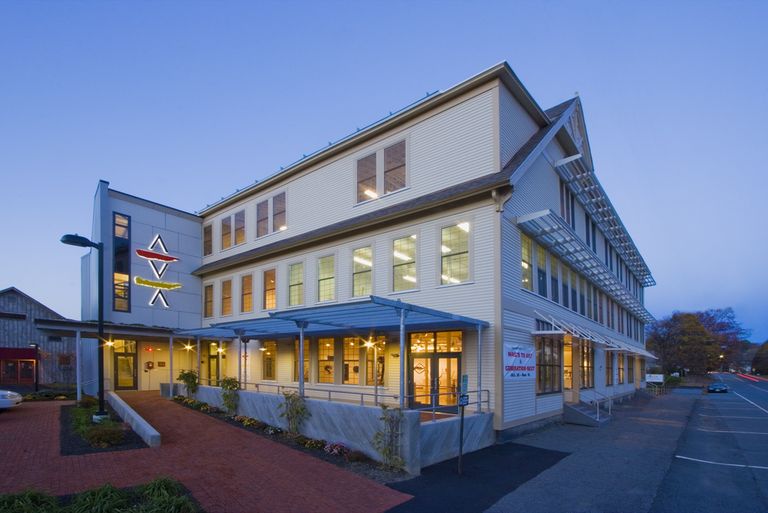 3-story clapboarded building with sun screens