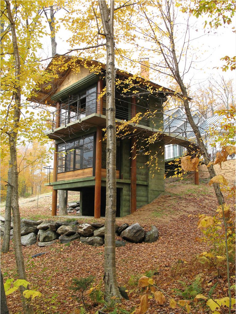 Tall, two story, concrete, wood and glass building in the trees